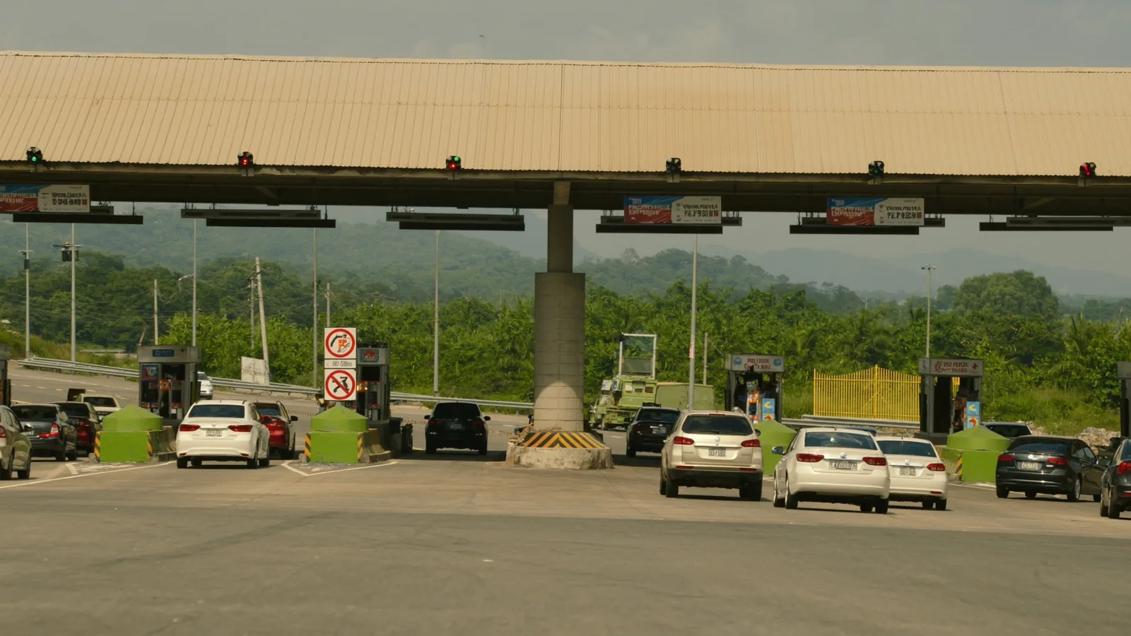 Cars queuing at the RFID lanes of a Philippine expressway toll plaza on a sunny afternoon
